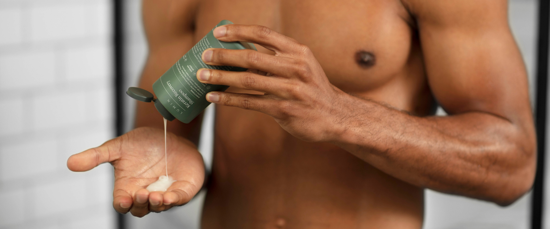 naked men pouring Lumin shower gel in his hand